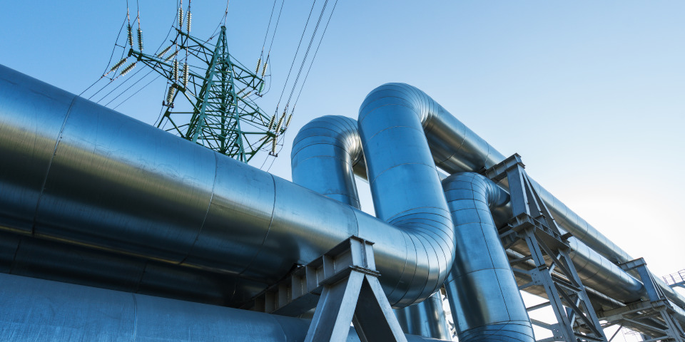 Industrial pipelines on pipe-bridge against blue sky
